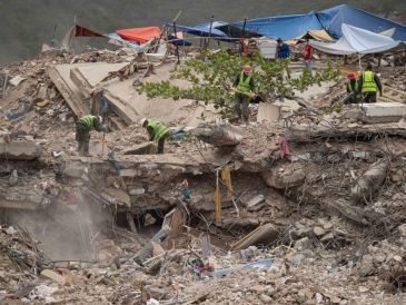 Personas remueven escombros de un edificio colapsado por los terremotos del 24 junio, este domingo en La Guaira, Venezuela. EFE/ R. Peña R