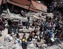 Personas buscan entre los escombros de una edificación colapsada por el terremoto de este lunes. EFE