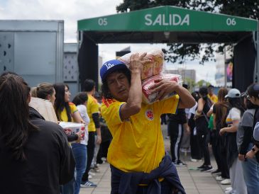 Personas organizan insumos en un centro de acopio en Bogotá. Cajas de alimentos, pañales y artículos de aseo son algunas de las ayudas que cientos de voluntarios reunieron en el estadio Nemesio Camacho El Campín. EFE/ P. Seco