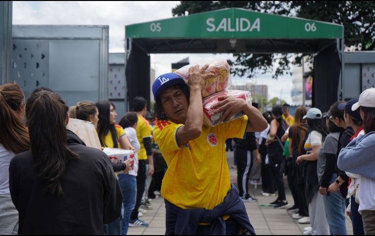 Personas organizan insumos en un centro de acopio en Bogotá. Cajas de alimentos, pañales y artículos de aseo son algunas de las ayudas que cientos de voluntarios reunieron en el estadio Nemesio Camacho El Campín. EFE/ P. Seco