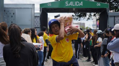 Personas organizan insumos en un centro de acopio en Bogotá. Cajas de alimentos, pañales y artículos de aseo son algunas de las ayudas que cientos de voluntarios reunieron en el estadio Nemesio Camacho El Campín. EFE/ P. Seco