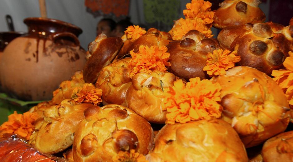Entre flores, veladoras, fotografías, papel picado de colores y otros elementos, también aparece el pan de muerto. NTX / ARCHIVO