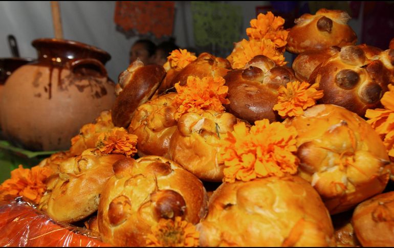Entre flores, veladoras, fotografías, papel picado de colores y otros elementos, también aparece el pan de muerto. NTX / ARCHIVO