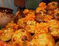 Entre flores, veladoras, fotografías, papel picado de colores y otros elementos, también aparece el pan de muerto. NTX / ARCHIVO
