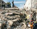 Los rescatistas sacan el cuerpo de una víctima de entre los escombros. AP
