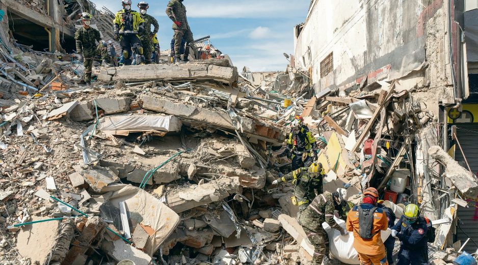 Los rescatistas sacan el cuerpo de una víctima de entre los escombros. AP