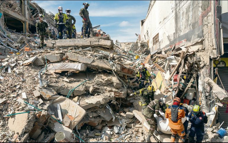 Los rescatistas sacan el cuerpo de una víctima de entre los escombros. AP