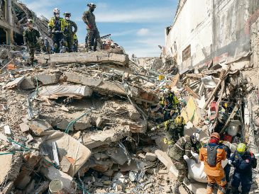 Los rescatistas sacan el cuerpo de una víctima de entre los escombros. AP