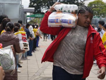 Personas organizan insumos en un centro de acopio este miércoles, en Bogotá. EFE/P. Seco