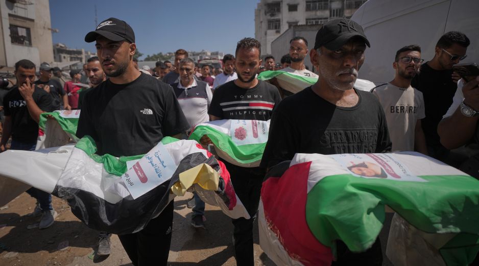 Dolientes cargan los cuerpos, cubiertos con banderas, de palestinos muertos en ataques israelíes durante la guerra contra Hamás, cuyos restos fueron recuperados recientemente de entre los escombros, en Ciudad de Gaza, el jueves 20 de agosto de 2026. Foto AP/J. Alshrafi