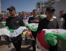 Dolientes cargan los cuerpos, cubiertos con banderas, de palestinos muertos en ataques israelíes durante la guerra contra Hamás, cuyos restos fueron recuperados recientemente de entre los escombros, en Ciudad de Gaza, el jueves 20 de agosto de 2026. Foto AP/J. Alshrafi
