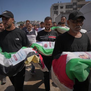 Dolientes cargan los cuerpos, cubiertos con banderas, de palestinos muertos en ataques israelíes durante la guerra contra Hamás, cuyos restos fueron recuperados recientemente de entre los escombros, en Ciudad de Gaza, el jueves 20 de agosto de 2026. Foto AP/J. Alshrafi