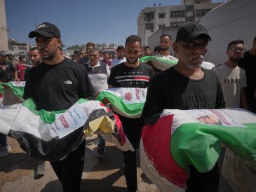 Dolientes cargan los cuerpos, cubiertos con banderas, de palestinos muertos en ataques israelíes durante la guerra contra Hamás, cuyos restos fueron recuperados recientemente de entre los escombros, en Ciudad de Gaza, el jueves 20 de agosto de 2026. Foto AP/J. Alshrafi