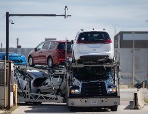 Un camión de transporte que lleva Chrysler Pacificas sale de la planta de ensamblaje de Windsor, en Ontario, Canadá. AP/D. Melmer