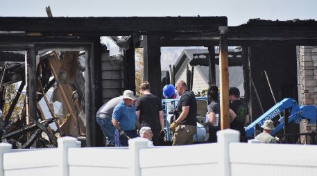 Investigadores trabajan en el sitio donde una familia fue asesinada y la casa incendiada, en Billings, Montana. AP/M. Brown