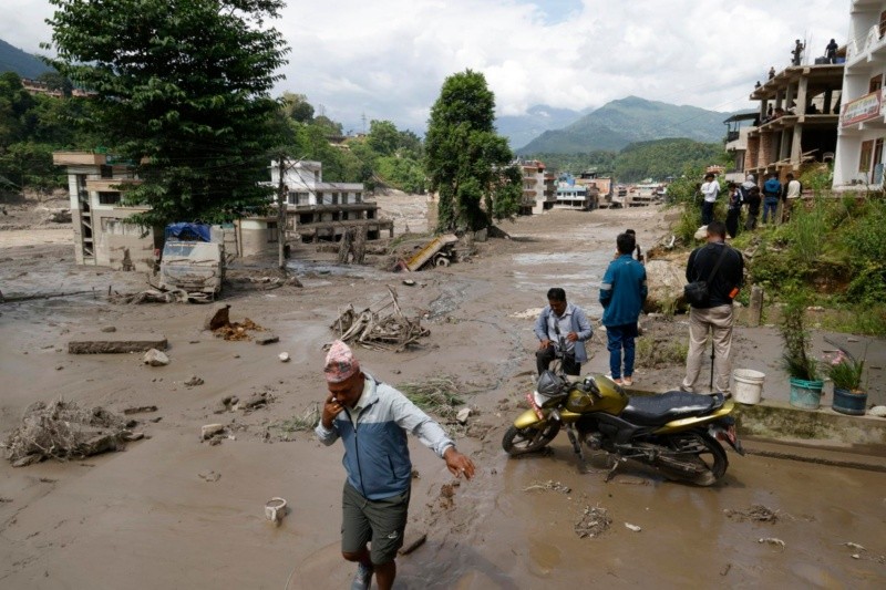 Habitantes de la zona caminan por calles inundadas tras una crecida repentina en Trishuli Bazar. EFE/EPA/NARENDRA SHRESTHA&nbsp;