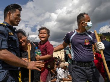 Personas reaccionan durante una operación de rescate realizada por un helicóptero del Ejército de Nepal tras unas inundaciones repentinas en la localidad de Hatigauda, distrito de Nuwakot (Nepal). EFE/EPA/N. Shrestha