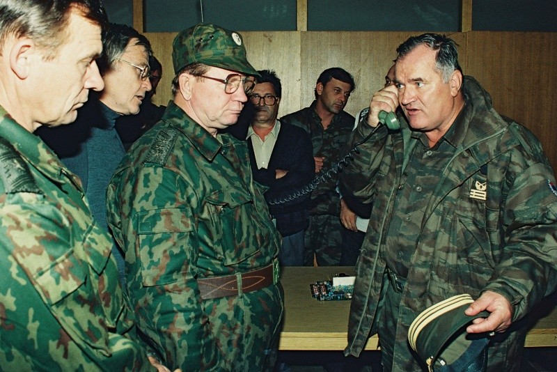 El general serbobosnio Ratko Mladic, derecha, habla por telefono junto al general del ejercito ruso, Vladimir Zurbenko, centro, durante la visita de una delegación de dicho organismo a la ciudad bosnia de Banja Luka, en octubre de1995. AP/Radivoje Pavicic