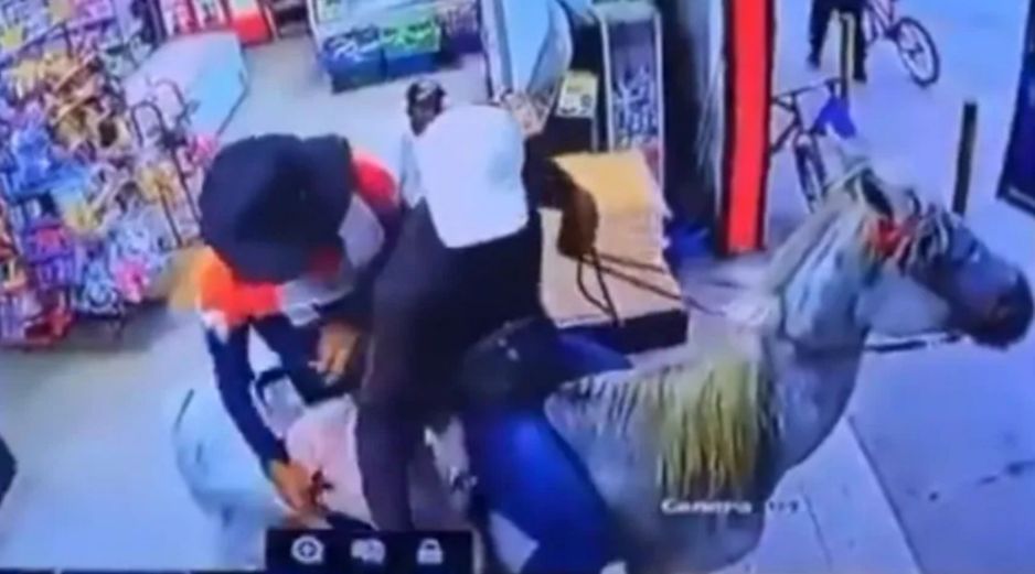 En la grabación se ve a los dos hombres montados a caballo con los rostros cubiertos y uno de ellos con un arma automática dentro del minisúper. CAPTURA DE VIDEO