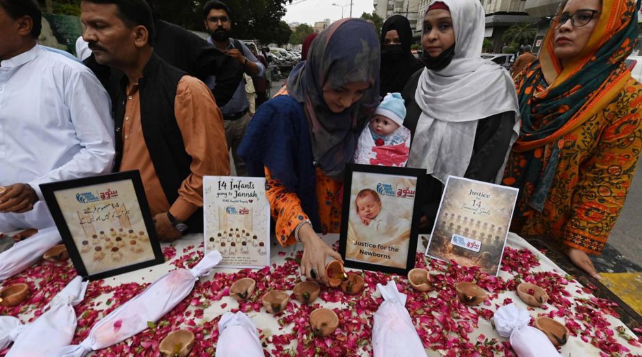 Activistas de derechos humanos celebran una vigilia con velas para honrar a los recién nacidos fallecidos en el incendio de un hospital en Karachi. EFE/S. Akber