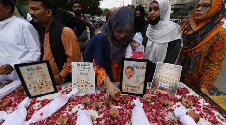 Activistas de derechos humanos celebran una vigilia con velas para honrar a los recién nacidos fallecidos en el incendio de un hospital en Karachi. EFE/S. Akber