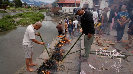 Unas personas realizan ritos simbólicos funerarios para sus familiares que siguen desaparecidos y se presumen muertos tras las inundaciones repentinas en Katmandú, Nepal, el miercoles 2 de septiembre de 2026. AP/D. Yasin