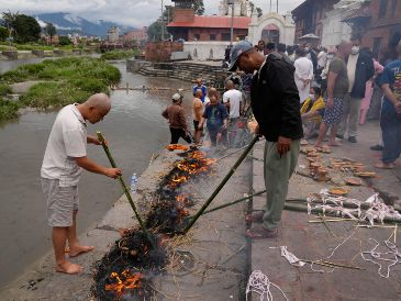 Unas personas realizan ritos simbólicos funerarios para sus familiares que siguen desaparecidos y se presumen muertos tras las inundaciones repentinas en Katmandú, Nepal, el miercoles 2 de septiembre de 2026. AP/D. Yasin