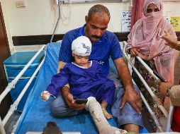 Un hombre acompaña a un niño que, según la prensa iraní, resultó herido en el ataque a una vivienda donde se celebraba una boda en la provincia de Kuhestak. AP/R. Poudat