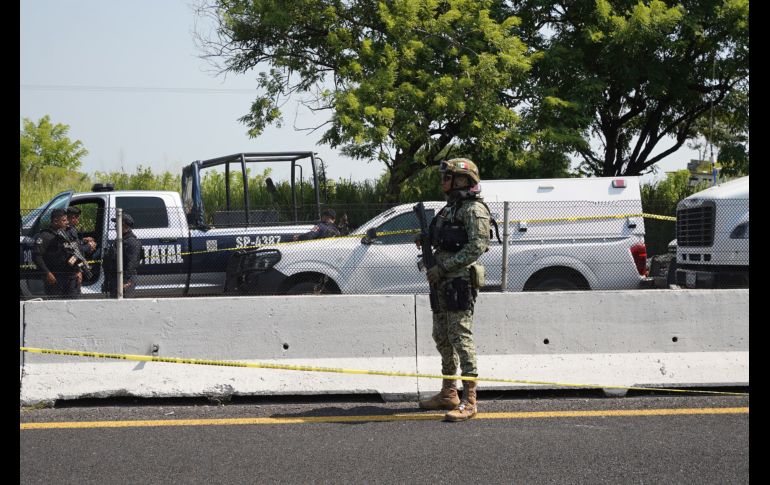 Un agente de la Policía Federal permanece junto a vehículos policiales cerca del lugar donde se halló el cuerpo del diputado Zenyazen Escobar García. AFP/V. Razo