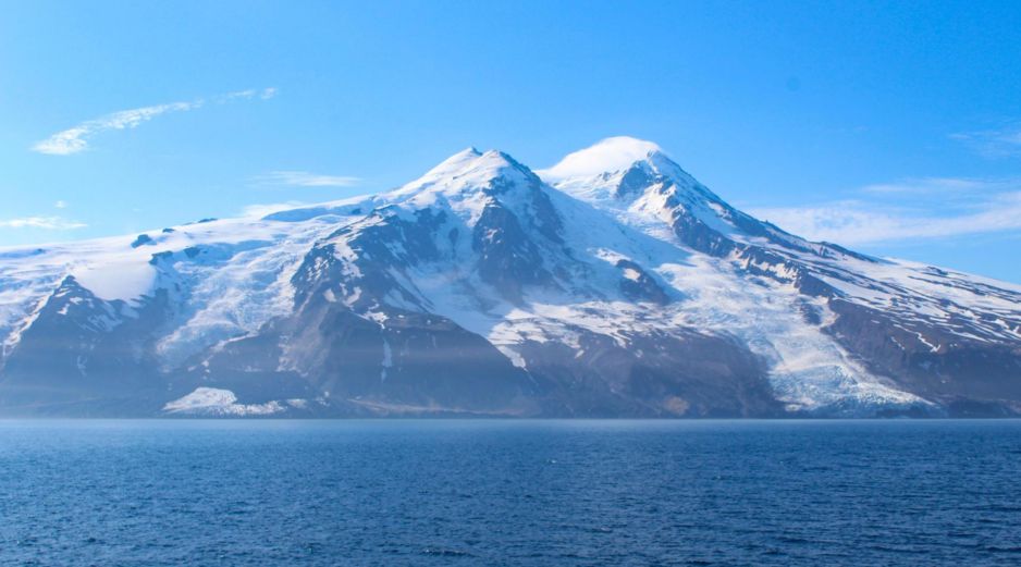 Los dos glaciares que rodean el volcán Beerenberg tras el alud de rocas: Provocado por un terremoto de magnitud 6,5, grandes cantidades de escombros volcánicos y de permafrost se desprendieron del glaciar Kjerulf, extendiendo el material por la superficie y cubriendo el hielo hasta la costa (lado izquierdo de la imagen). EFE/ Fotografía facilitada por Grace Angelo.