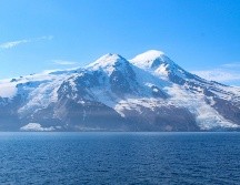 Los dos glaciares que rodean el volcán Beerenberg tras el alud de rocas: Provocado por un terremoto de magnitud 6,5, grandes cantidades de escombros volcánicos y de permafrost se desprendieron del glaciar Kjerulf, extendiendo el material por la superficie y cubriendo el hielo hasta la costa (lado izquierdo de la imagen). EFE/ Fotografía facilitada por Grace Angelo.
