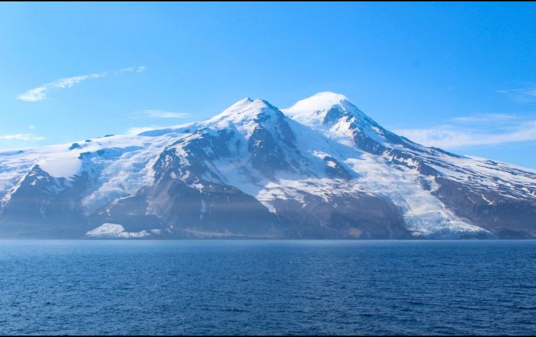 Los dos glaciares que rodean el volcán Beerenberg tras el alud de rocas: Provocado por un terremoto de magnitud 6,5, grandes cantidades de escombros volcánicos y de permafrost se desprendieron del glaciar Kjerulf, extendiendo el material por la superficie y cubriendo el hielo hasta la costa (lado izquierdo de la imagen). EFE/ Fotografía facilitada por Grace Angelo.