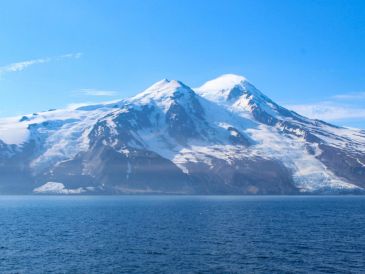 Los dos glaciares que rodean el volcán Beerenberg tras el alud de rocas: Provocado por un terremoto de magnitud 6,5, grandes cantidades de escombros volcánicos y de permafrost se desprendieron del glaciar Kjerulf, extendiendo el material por la superficie y cubriendo el hielo hasta la costa (lado izquierdo de la imagen). EFE/ Fotografía facilitada por Grace Angelo.