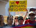 Una mujer sostiene un cartel este lunes en el lugar donde un inmigrante venezolano recibió un disparo por la espalda de un agente del ICE el pasado domingo en Austin. EFE/C. Ramírez
