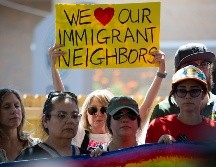 Una mujer sostiene un cartel este lunes en el lugar donde un inmigrante venezolano recibió un disparo por la espalda de un agente del ICE el pasado domingo en Austin. EFE/C. Ramírez