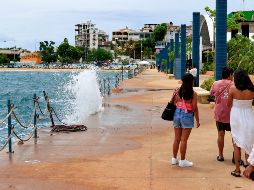 Personas caminan por el malecón con fuerte oleaje ante el paso del huracán 'Polo' este martes en Acapulco. EFE/D. Guzmán