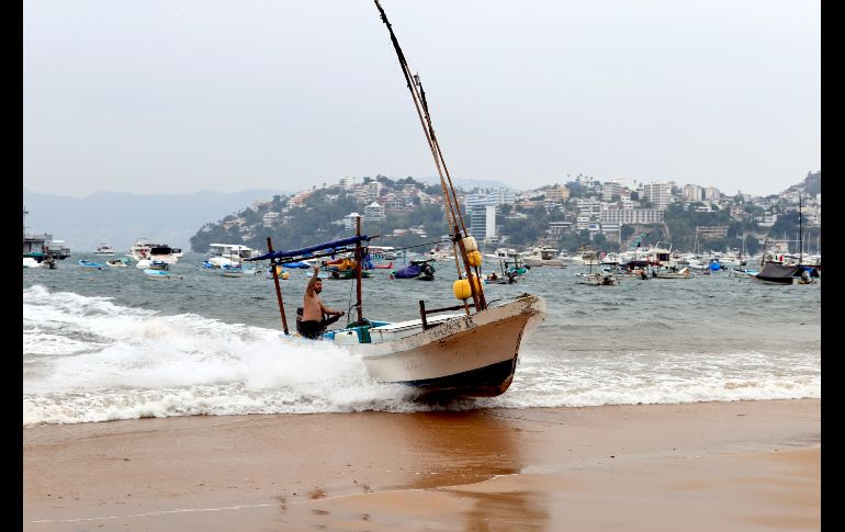 Pescadores retiran del agua una embarcación ante el paso del huracán 'Polo' este miércoles en Acapulco, Guerrero. EFE/D. Guzmán