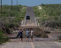 Varios hombres inspeccionan una carretera dañada por la crecida de un río a lo largo de la ruta hacia Las Barrancas, en Baja California Sur. AP/E. Verdugo