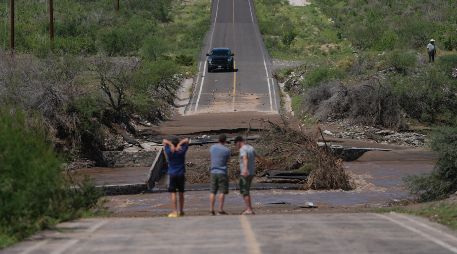 Varios hombres inspeccionan una carretera dañada por la crecida de un río a lo largo de la ruta hacia Las Barrancas, en Baja California Sur. AP/E. Verdugo