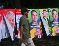 Un hombre camina frente a una tienda informal de banderas con la imagen del presidente de Brasil y candidato a la reelección, Luiz Inácio Lula da Silva, y del candidato presidencial, Flávio Bolsonaro. EFE/A. Borges