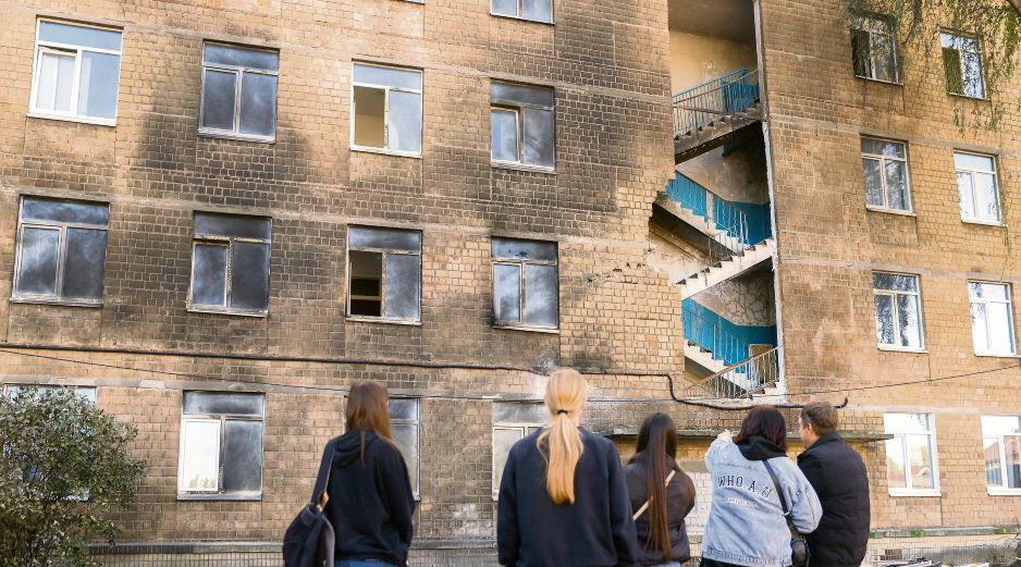 Un grupo de estudiantes en Kiev observa su escuela, impactada por drones rusos durante los últimos días. EFE