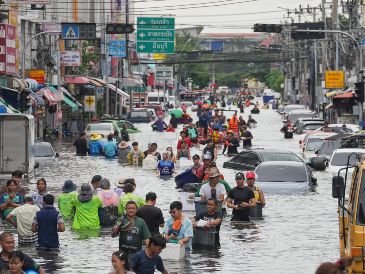 Personas caminan por una calle inundada tras fuertes lluvias en Bangkok, Tailandia. AP/S. Lalit