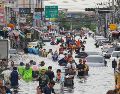 Personas caminan por una calle inundada tras fuertes lluvias en Bangkok, Tailandia. AP/S. Lalit