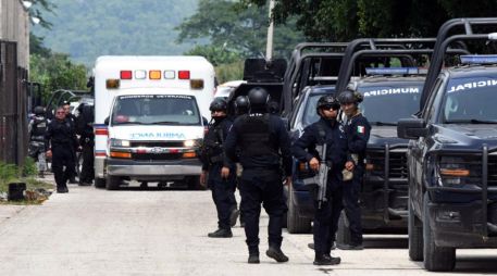 Integrantes de la policía vigilan afuera de las instalaciones del penal El Castillo este jueves luego de la riña que dejó 10 muertos. EFE/F. Mcconegly