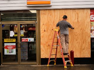 Jason Coffey coloca tablones en una tienda en una gasolinera mientras el huracán Isaías se acerca a Pensacola Beach, Florida. AP/G. Herbert