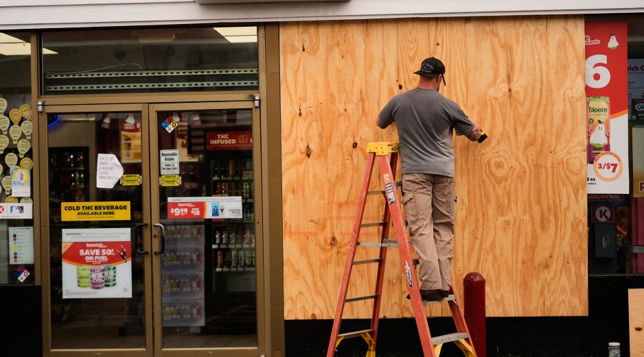 Jason Coffey coloca tablones en una tienda en una gasolinera mientras el huracán Isaías se acerca a Pensacola Beach, Florida. AP/G. Herbert
