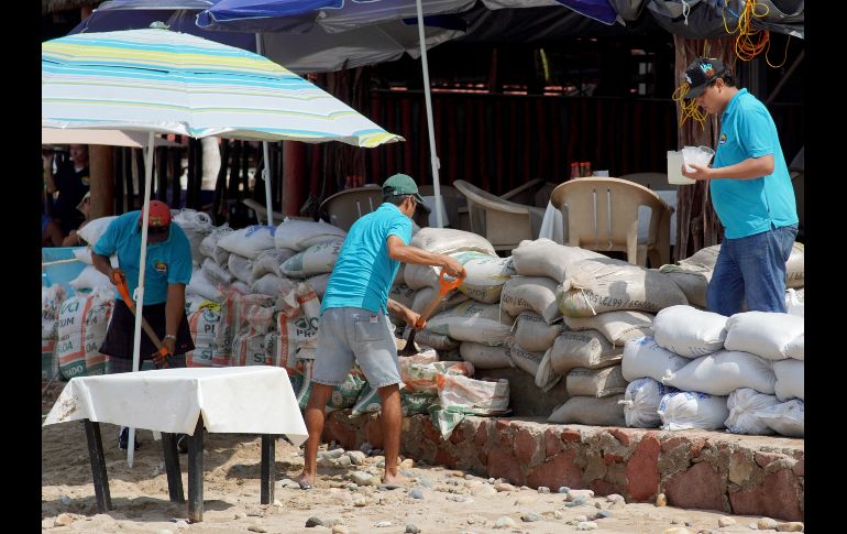 Trabajadores de negocios y restaurantes alistan barricadas ante el paso del huracán 