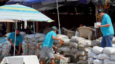 Trabajadores de negocios y restaurantes alistan barricadas ante el paso del huracán 