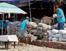 Trabajadores de negocios y restaurantes alistan barricadas ante el paso del huracán 
