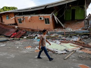 Un hombre camina cerca de una vivienda afectada el terremoto este sábado, en Tonosí, Panamá. EFE/B. Velasco